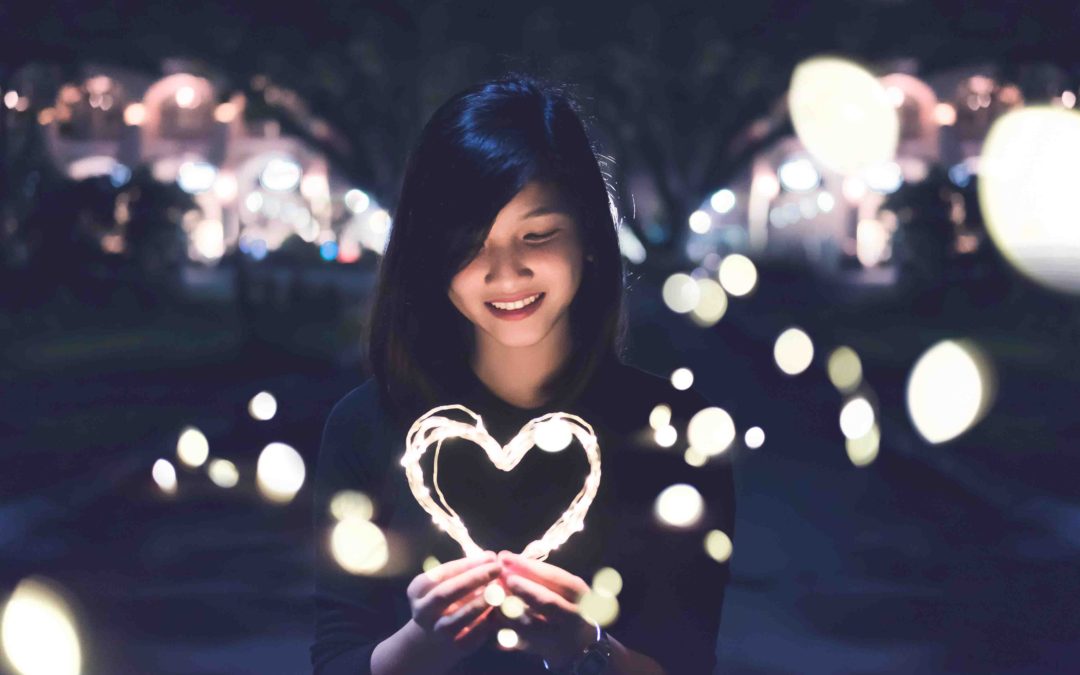woman holding luminous heart